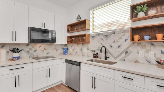 kitchen with white cabinetry, sink, tasteful backsplash, and black appliances