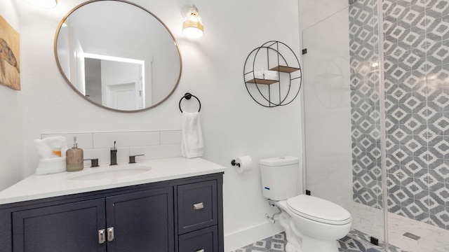 bathroom featuring tile flooring, tasteful backsplash, toilet, a tile shower, and oversized vanity