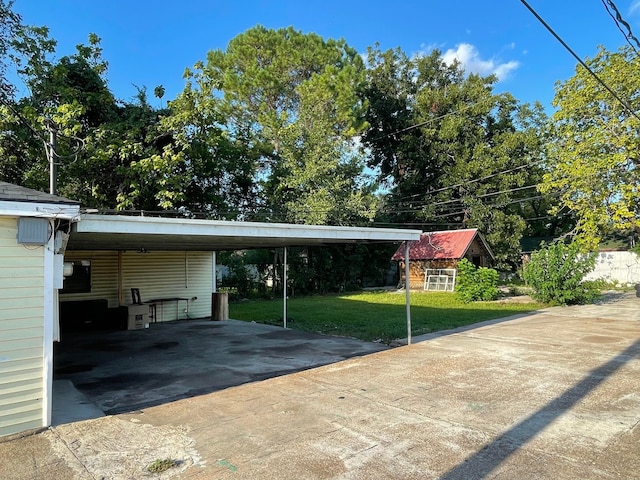 view of vehicle parking with a carport and a yard