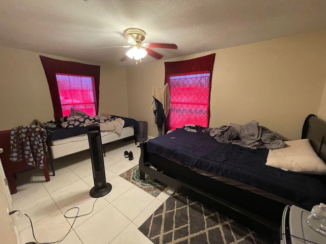 tiled bedroom featuring a textured ceiling and ceiling fan