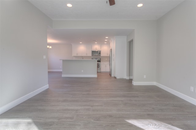 unfurnished living room with ceiling fan and light hardwood / wood-style flooring