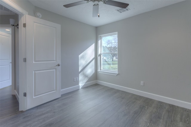 empty room with dark hardwood / wood-style flooring and ceiling fan