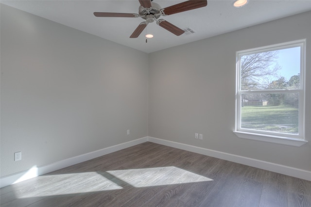 unfurnished room featuring ceiling fan, dark wood-type flooring, and a healthy amount of sunlight