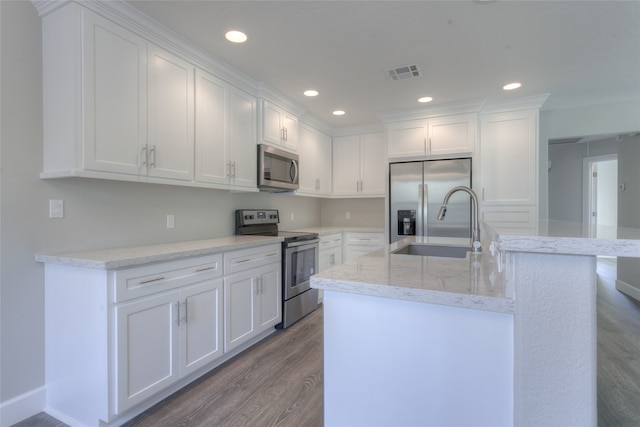 kitchen with light hardwood / wood-style floors, light stone countertops, stainless steel appliances, and white cabinetry