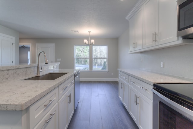 kitchen featuring pendant lighting, sink, appliances with stainless steel finishes, a chandelier, and dark wood-type flooring