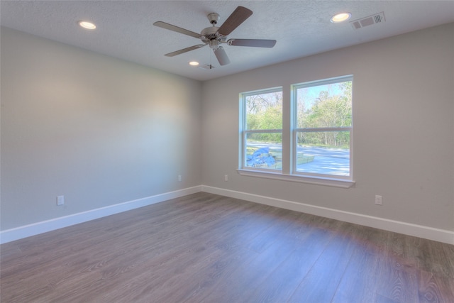 unfurnished room featuring ceiling fan, a textured ceiling, and dark hardwood / wood-style flooring