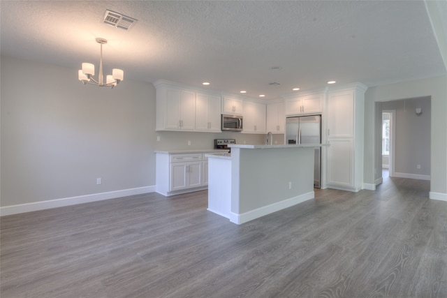 kitchen featuring a center island, a notable chandelier, stainless steel appliances, dark hardwood / wood-style flooring, and white cabinets