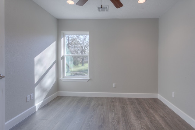 spare room featuring plenty of natural light, ceiling fan, and hardwood / wood-style flooring