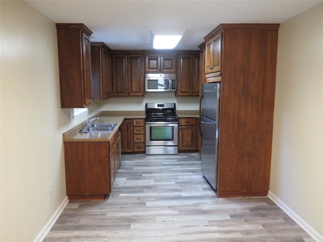 kitchen featuring light hardwood / wood-style floors, appliances with stainless steel finishes, and sink