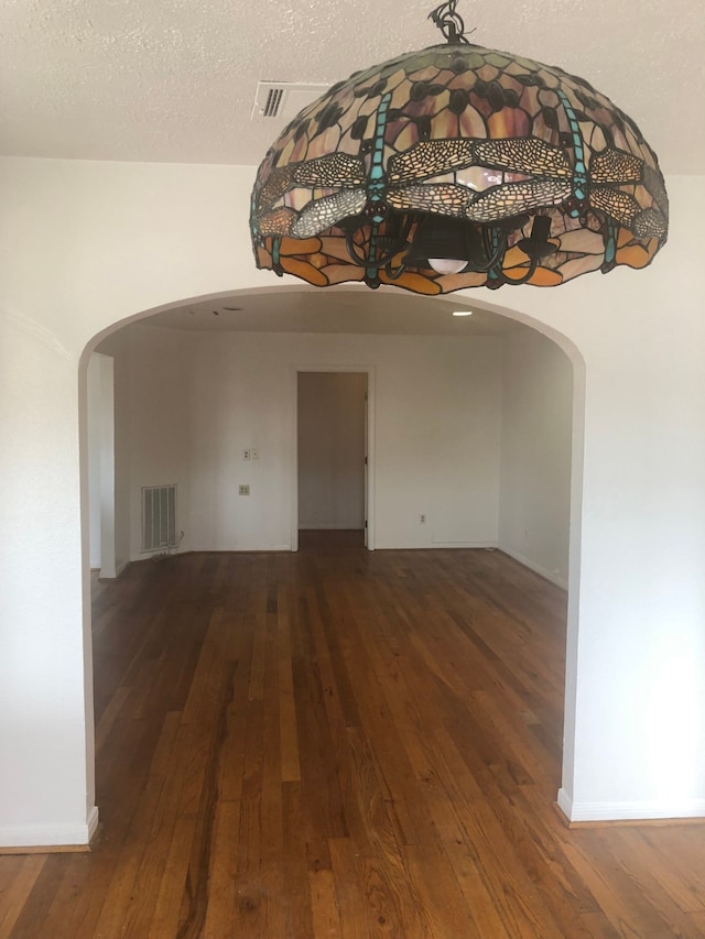 spare room featuring a textured ceiling and wood-type flooring