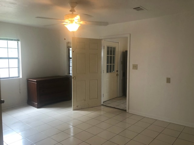 tiled spare room with ceiling fan