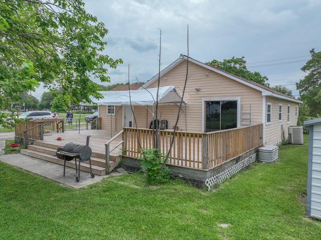 rear view of house with a yard, central air condition unit, and a wooden deck