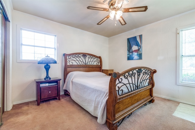 bedroom featuring ceiling fan, multiple windows, and light colored carpet