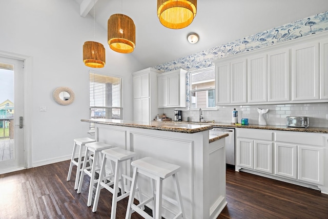 kitchen with backsplash, hanging light fixtures, dark wood-type flooring, and white cabinetry