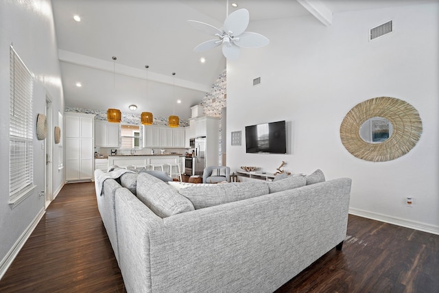 living room with dark wood-type flooring, ceiling fan, high vaulted ceiling, and beam ceiling