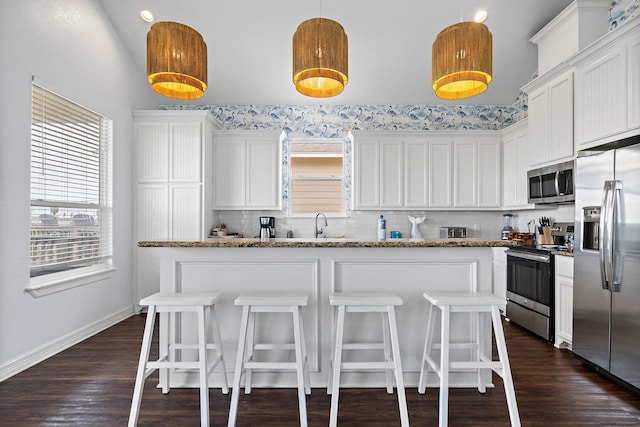 kitchen with white cabinets, appliances with stainless steel finishes, and dark wood-type flooring