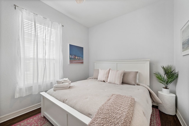 bedroom with dark hardwood / wood-style floors