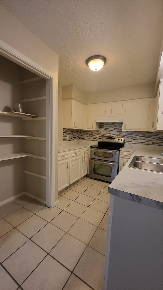 kitchen featuring white cabinetry, double oven range, tasteful backsplash, and sink