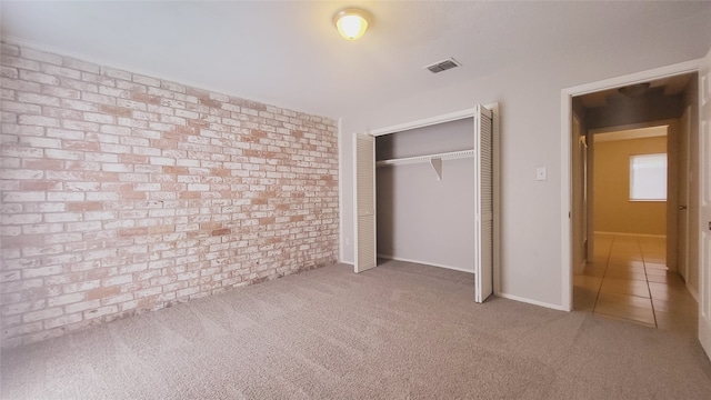 unfurnished bedroom with light carpet and a closet