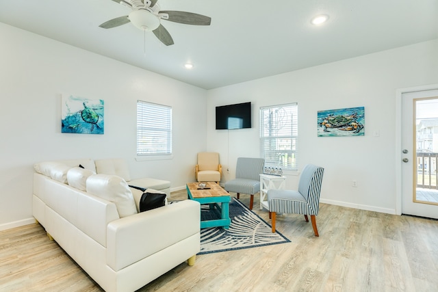 living room featuring a healthy amount of sunlight, light hardwood / wood-style floors, and ceiling fan