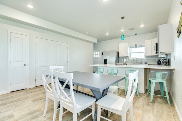 dining space featuring light hardwood / wood-style flooring and sink