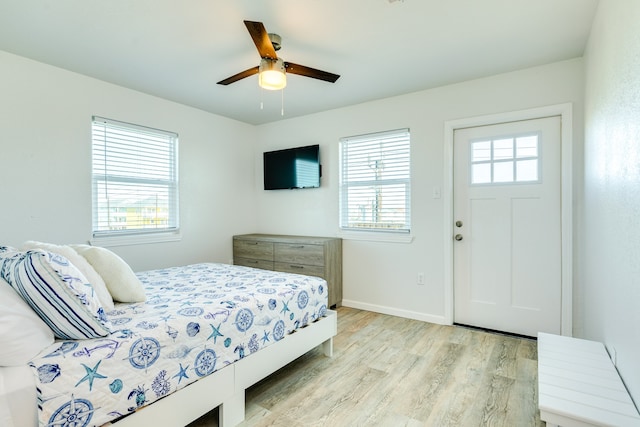 bedroom featuring multiple windows, light hardwood / wood-style flooring, and ceiling fan