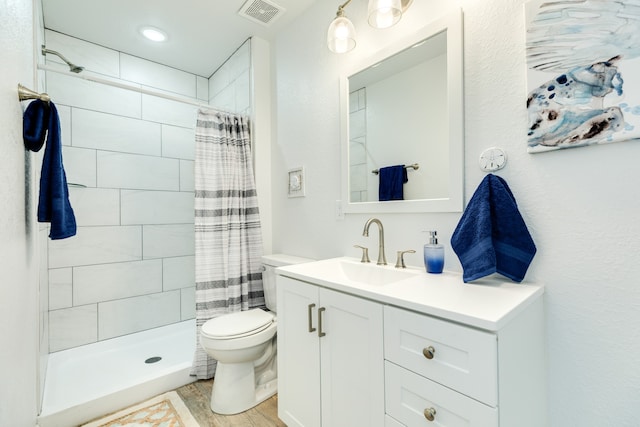 bathroom featuring a shower with curtain, toilet, vanity, and wood-type flooring