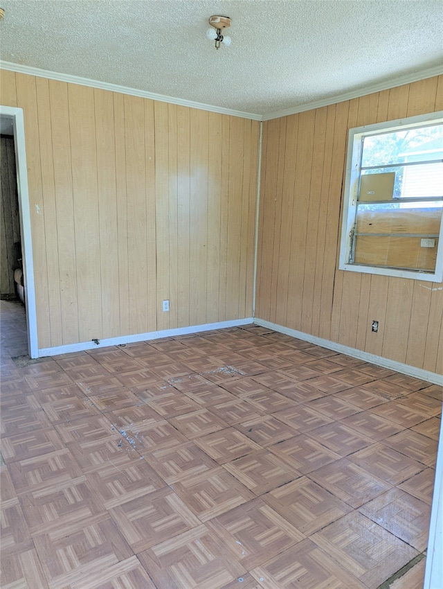 spare room with wooden walls, a textured ceiling, and dark parquet flooring