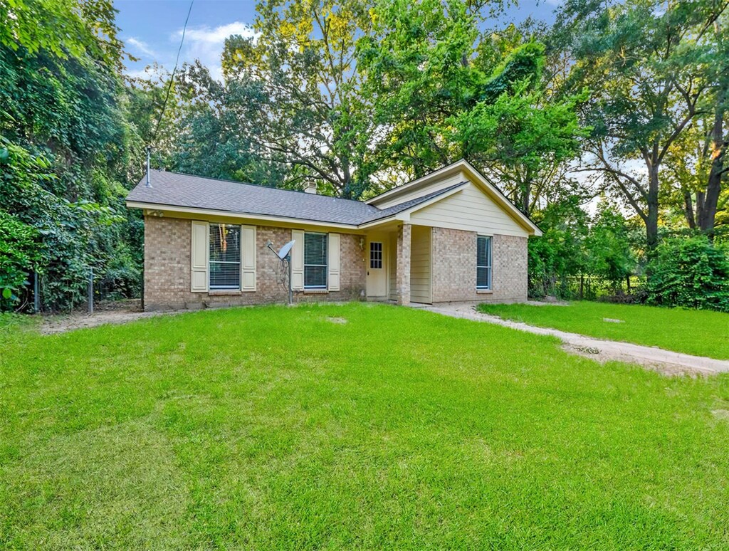 4040 State Highway 156, Coldspring, TX 77331 - ranch-style house with a front yard
