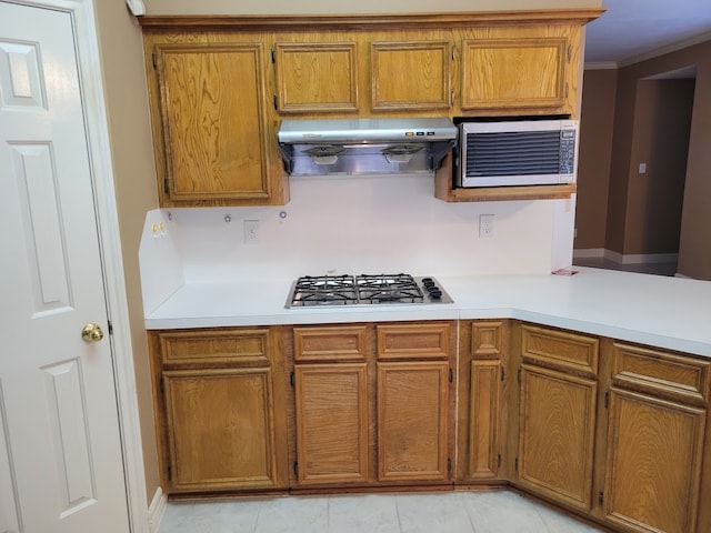 kitchen with extractor fan, appliances with stainless steel finishes, and light tile flooring