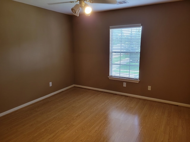 spare room featuring ceiling fan, light hardwood / wood-style flooring, and a wealth of natural light