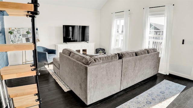 living room featuring dark hardwood / wood-style floors, a healthy amount of sunlight, and vaulted ceiling