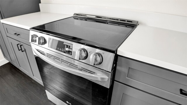 interior details with stainless steel range with electric cooktop and dark hardwood / wood-style flooring