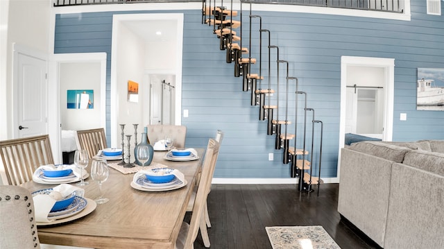 dining room featuring a barn door and dark wood-type flooring