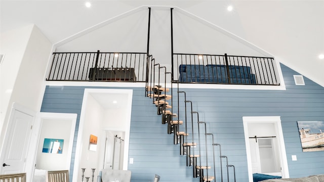 staircase with a barn door and a high ceiling