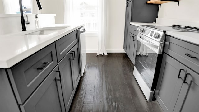 kitchen with sink, dark hardwood / wood-style floors, gray cabinets, and electric range