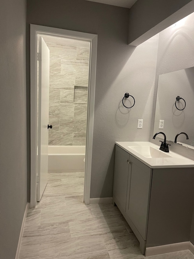 bathroom featuring tile patterned flooring, tiled shower / bath combo, and vanity