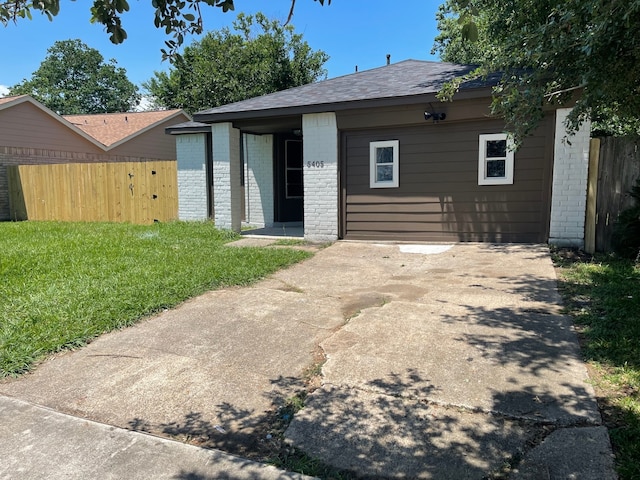 view of front of home featuring brick siding, a front yard, fence, and driveway