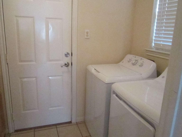 laundry area with light tile patterned floors and washing machine and clothes dryer