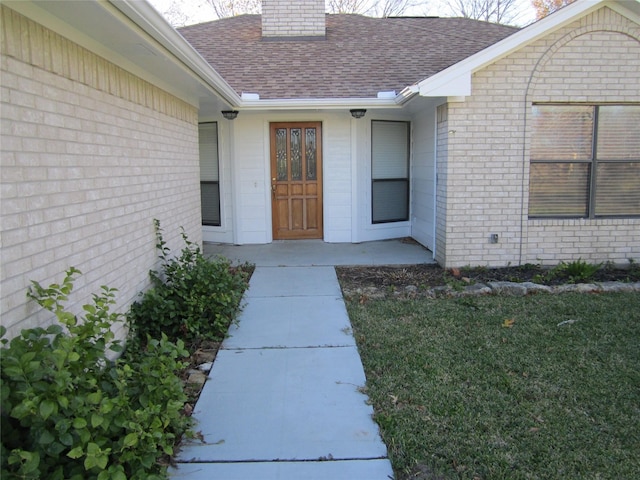 doorway to property with a lawn