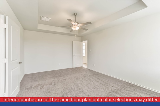 interior space with a raised ceiling, ceiling fan, and light carpet