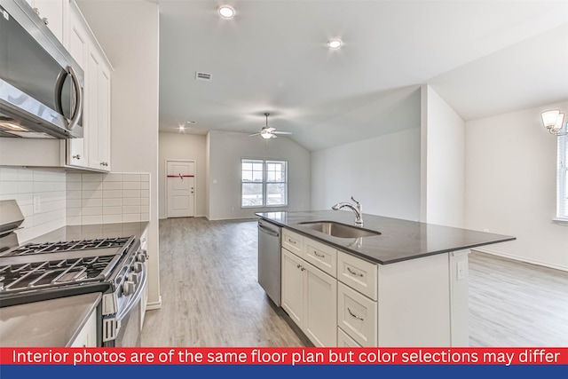 kitchen with appliances with stainless steel finishes, backsplash, sink, light hardwood / wood-style flooring, and white cabinets