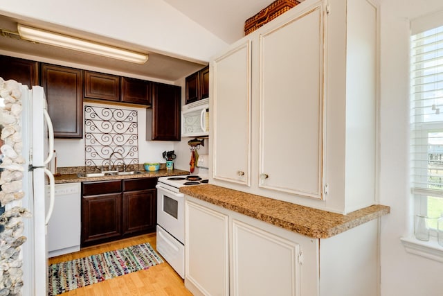 kitchen featuring white appliances, light hardwood / wood-style floors, a healthy amount of sunlight, and sink