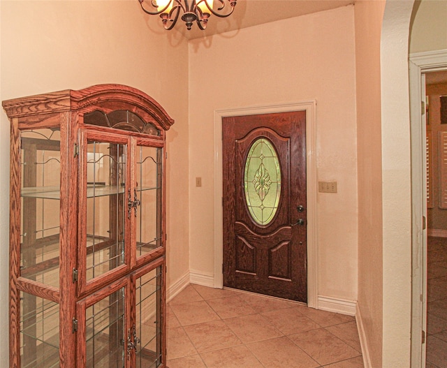 tiled entrance foyer with a notable chandelier