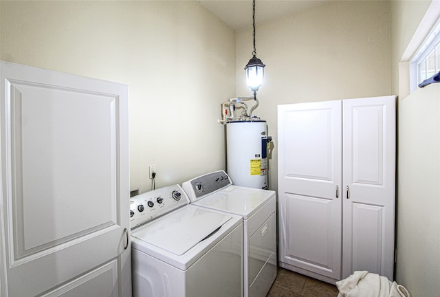 laundry room with independent washer and dryer, cabinets, dark tile patterned flooring, and water heater