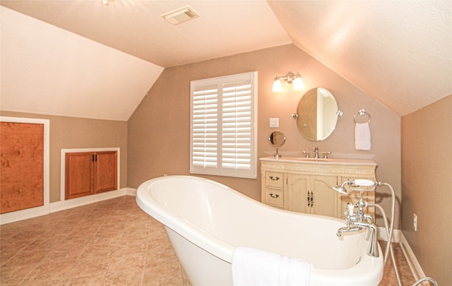 bathroom with lofted ceiling, a bathtub, and vanity