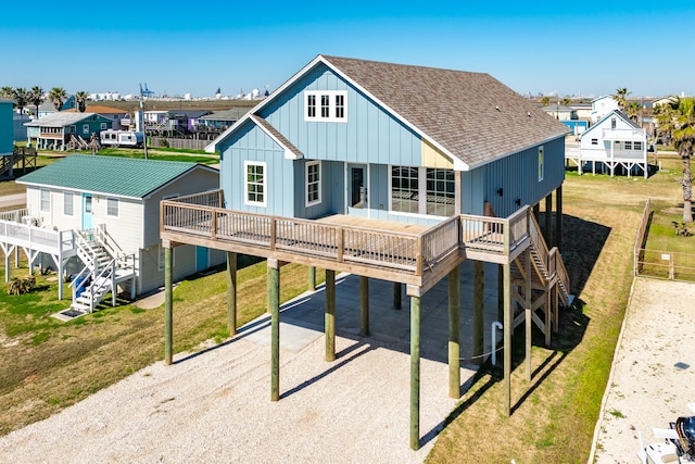 rear view of property featuring a wooden deck and a lawn