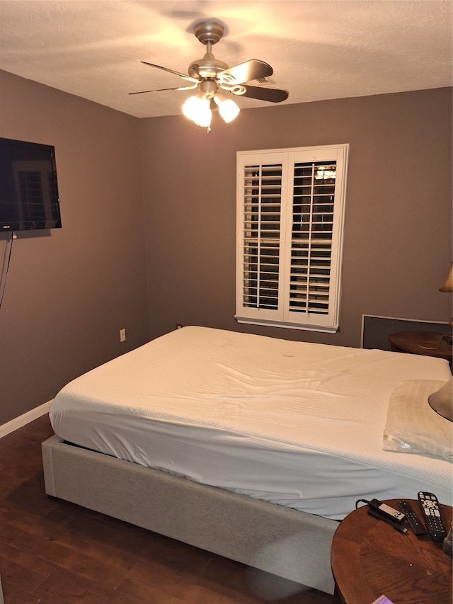 bedroom featuring ceiling fan and dark hardwood / wood-style floors