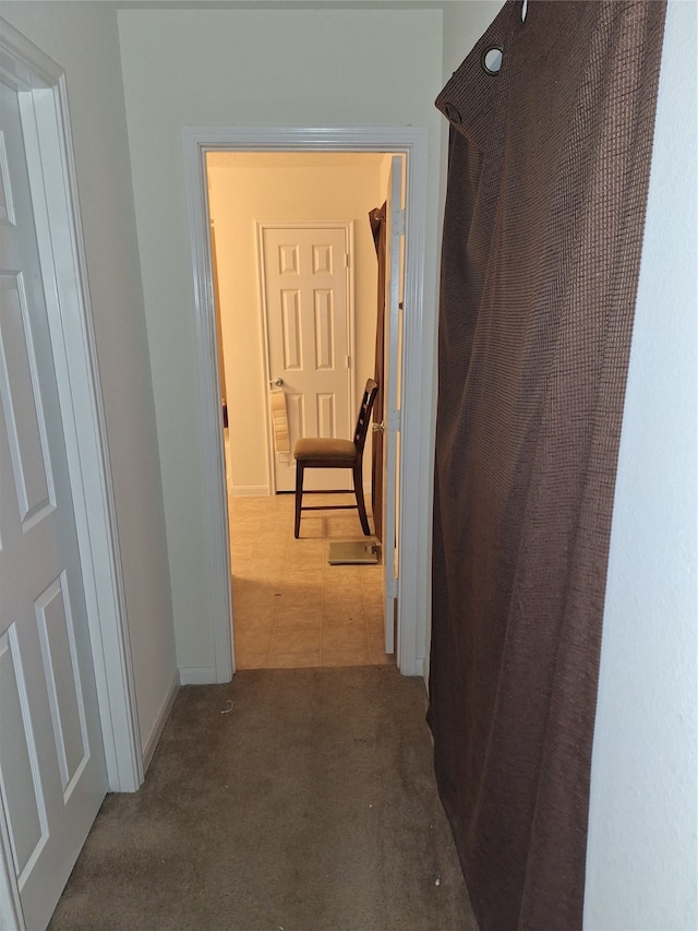 hallway featuring dark tile flooring