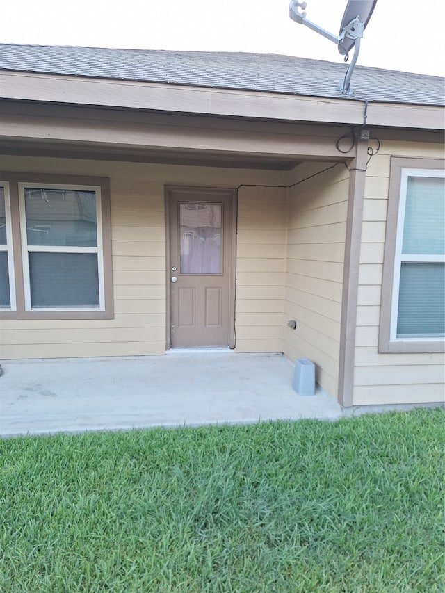 property entrance with a lawn